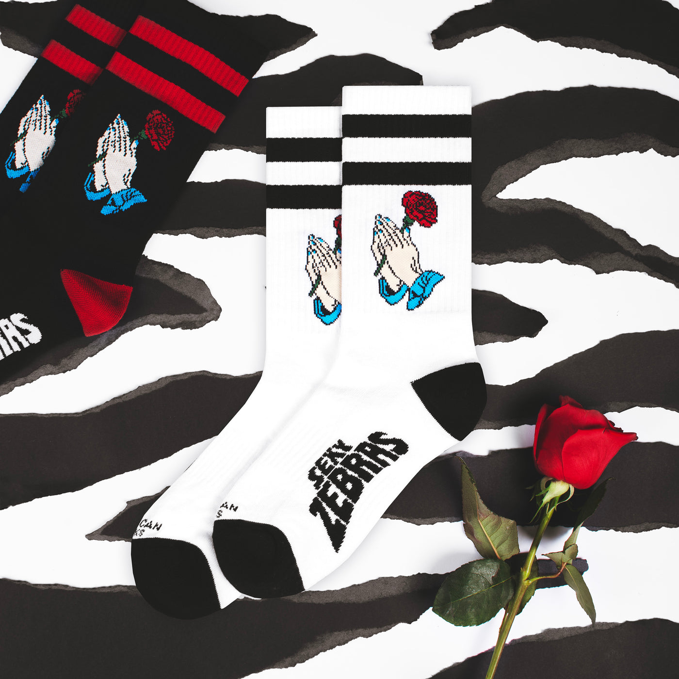 White and black fun crew socks with hands holding a rose flower with black and red version on the side american socks