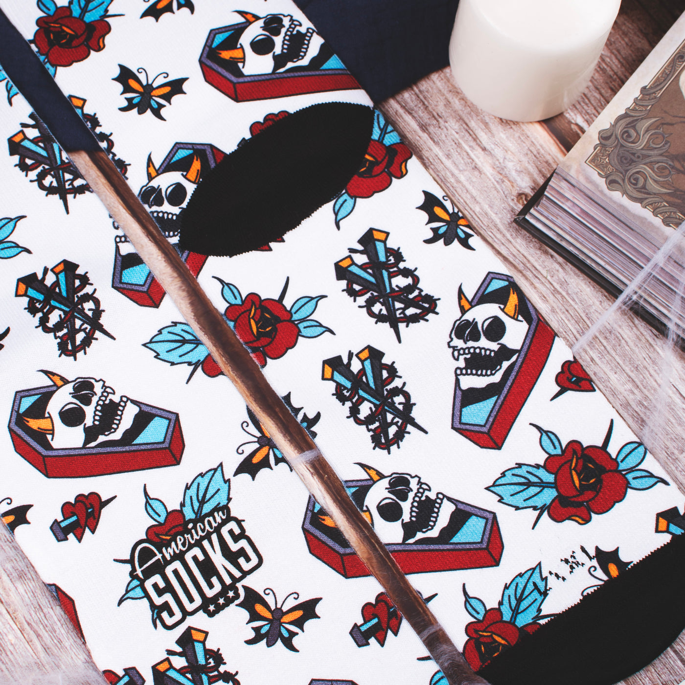 Close up of death inspired socks with tattoo illustrations of skull roses and graves american socks 