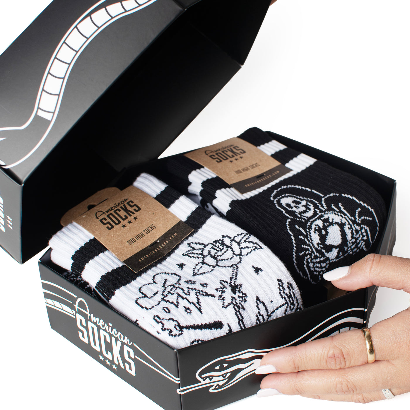 Hand holding skull giftbox with socks inside by american socks