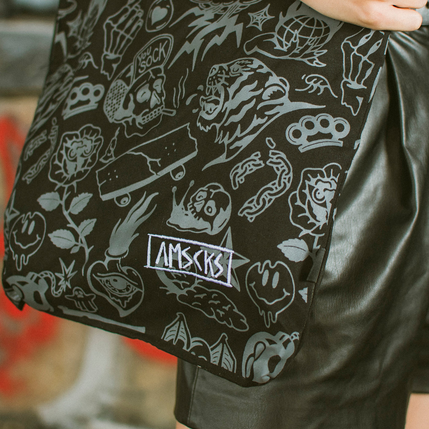Close up of american socks black tote bag with gray chaotic doodles including punk skater metal pattern such as skulls fists and skateboards