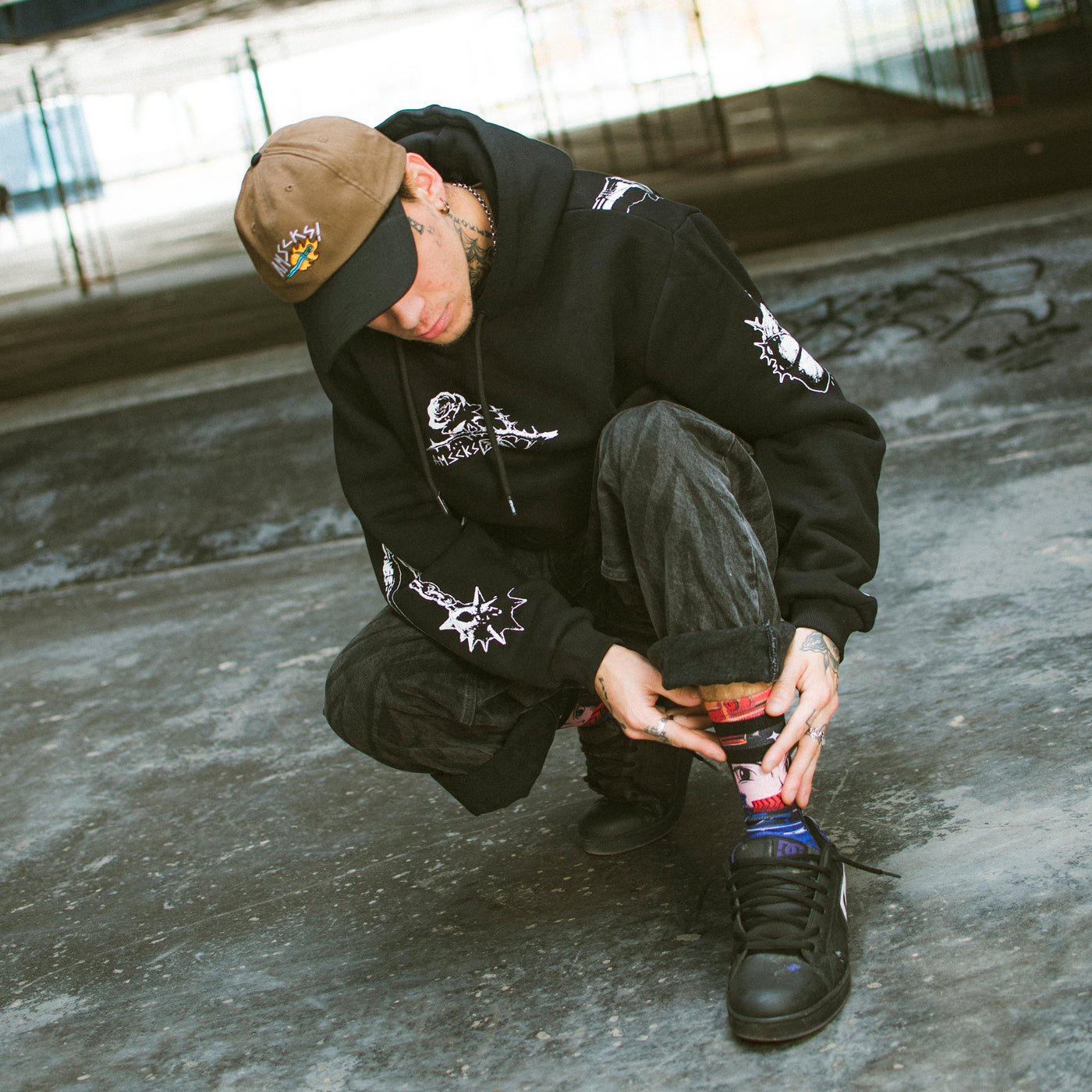 Man wearing streetwear fashion showing cool japanese illustration socks and american socks cap 