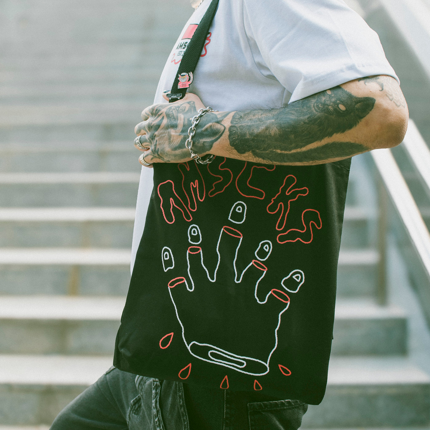 Person carrying cool alternative tote bag with surreal edgy hand design with cut fingers american socks